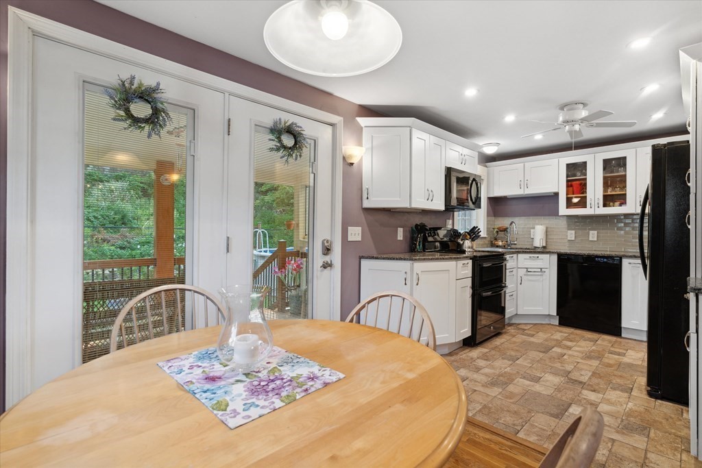 13 Surrey Road Salem, MA 01970 - Photo 9 of 42 a kitchen with stainless steel appliances kitchen island granite countertop a refrigerator a stove a sink dishwasher with a dining table and chairs