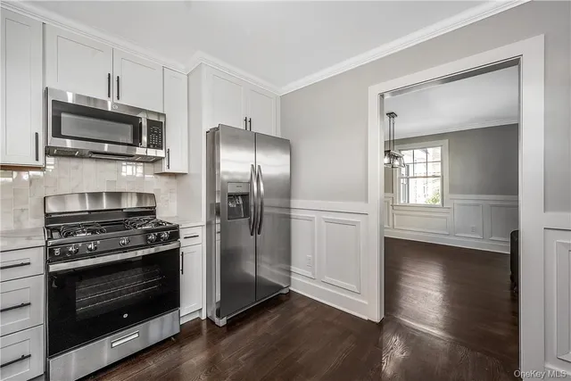 a kitchen with stainless steel appliances a stove a microwave and a hard wood floors