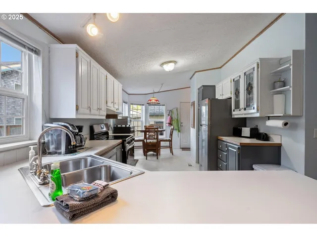 a kitchen with stainless steel appliances kitchen island granite countertop a refrigerator and a sink