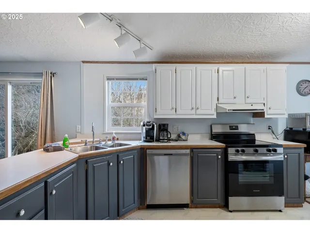a kitchen with stainless steel appliances a sink stove and cabinets