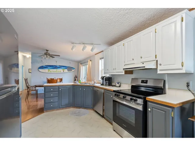 a kitchen with stainless steel appliances granite countertop a stove cabinets and wooden floor