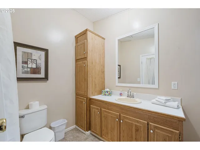 a bathroom with a sink a toilet a mirror and shower