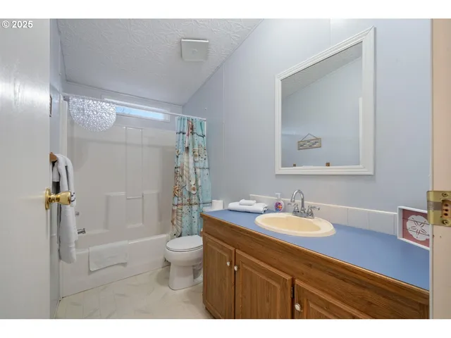 a bathroom with a sink a toilet a shower and a mirror