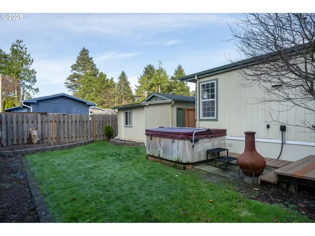 a view of a backyard with table and chairs potted plants and wooden fence