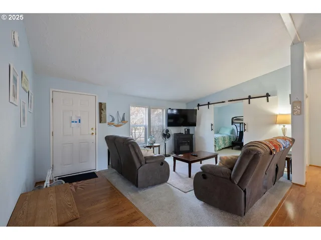 a living room with furniture a flat screen tv and a window