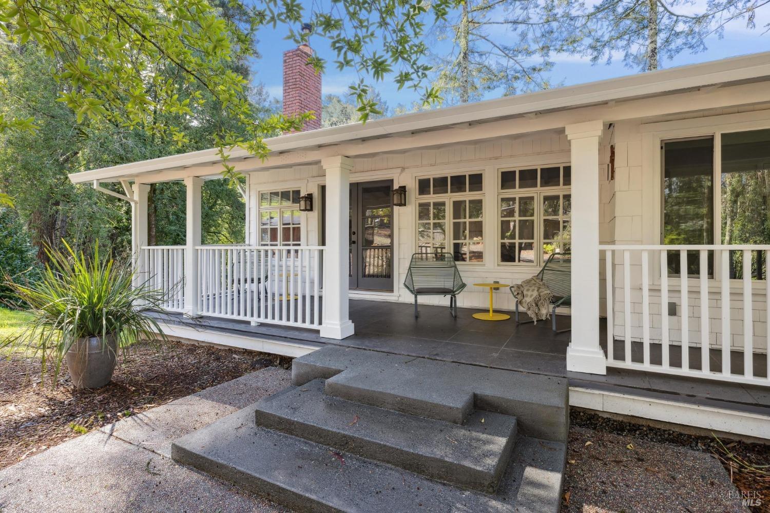a porch with a bench next to a yard