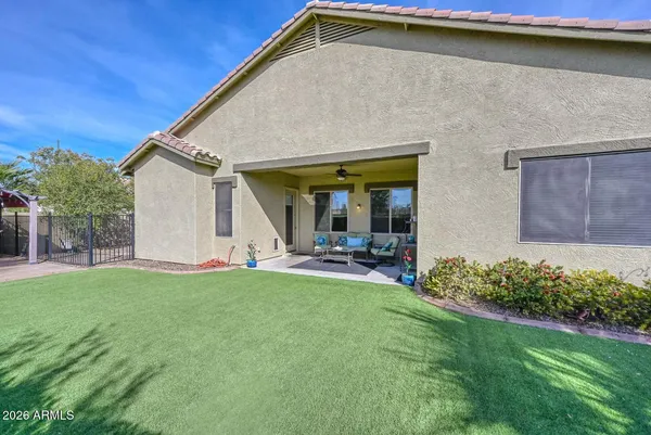 a view of a chair and table in backyard of the house
