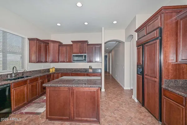 a kitchen with stainless steel appliances kitchen island granite countertop a refrigerator and a stove top oven