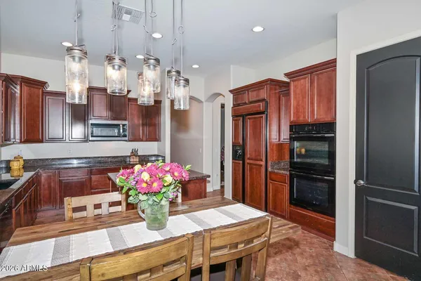 a dining room with furniture a chandelier and wooden floor