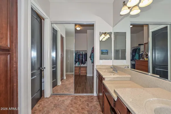 a bathroom with a granite countertop sink a large mirror and a shower