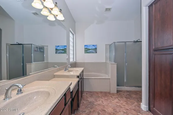 a bathroom with a tub a double vanity sink and a mirror