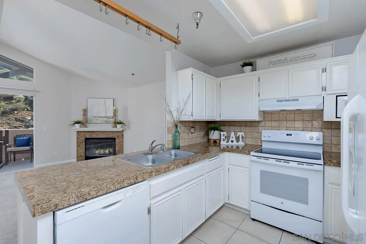17161 Alva Road, Unit 931 San Diego, CA 92127 - Photo 4 of 30 a kitchen with granite countertop a sink stainless steel appliances and white cabinets