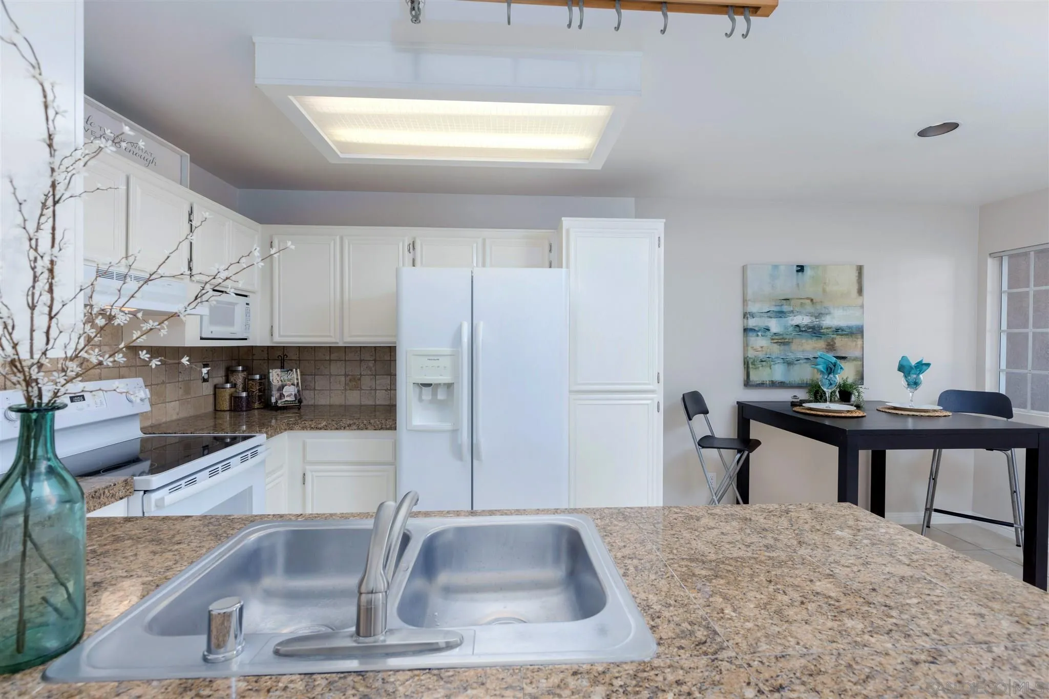 17161 Alva Road, Unit 931 San Diego, CA 92127 - Photo 5 of 30 a kitchen with kitchen island a sink stove and cabinets