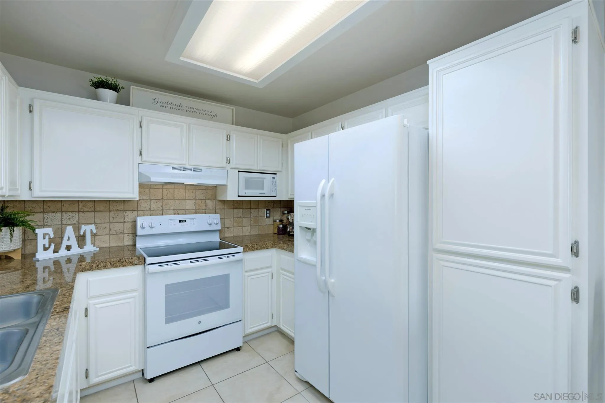 17161 Alva Road, Unit 931 San Diego, CA 92127 - Photo 7 of 30 a kitchen with white cabinets and white appliances
