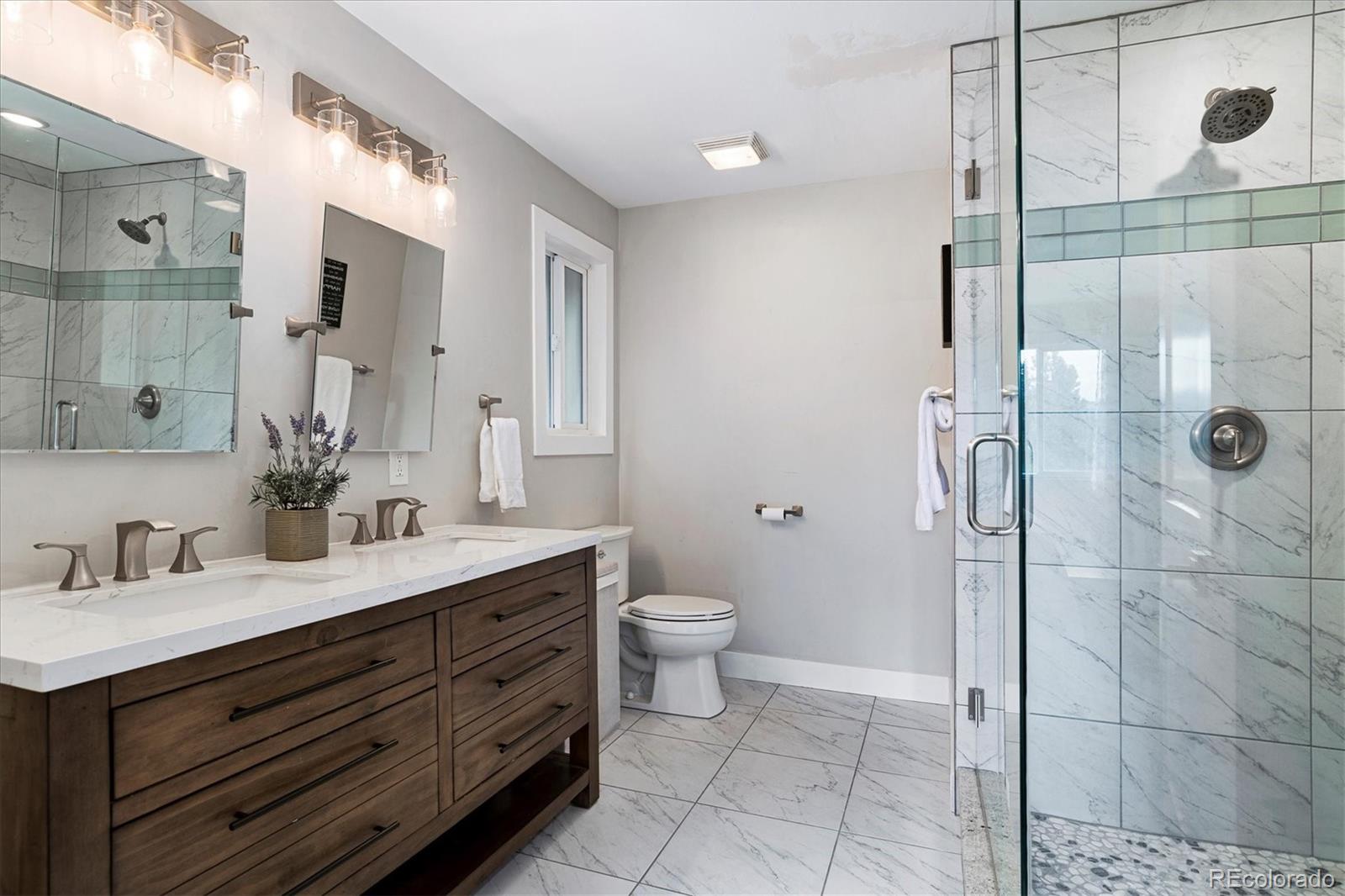 28867 Cedar Circle Evergreen, CO 80439 - Photo 11 of 35 a bathroom with a double vanity sink toilet and shower