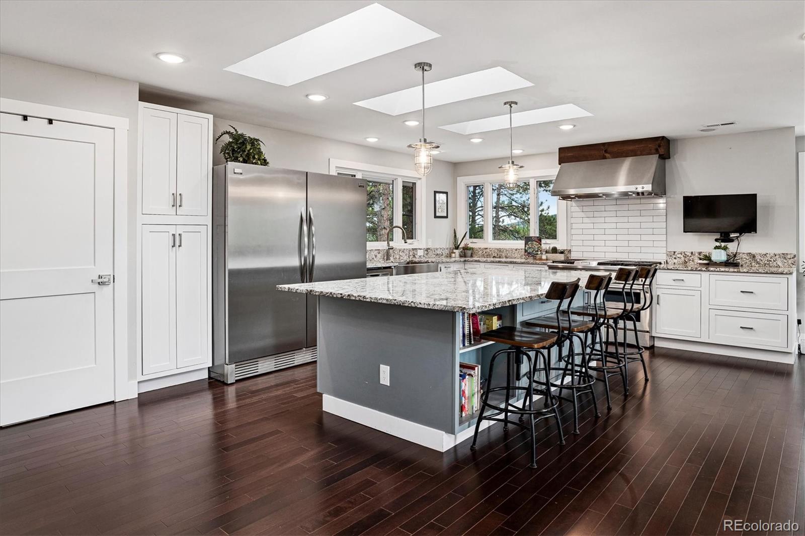 28867 Cedar Circle Evergreen, CO 80439 - Photo 3 of 35 a kitchen with stainless steel appliances granite countertop a table chairs refrigerator and sink