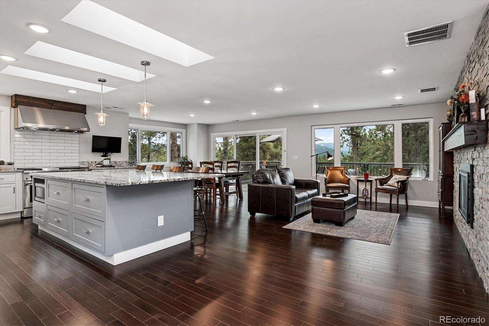 28867 Cedar Circle Evergreen, CO 80439 - Photo 4 of 35 a living room with lots of furniture kitchen view and a large window