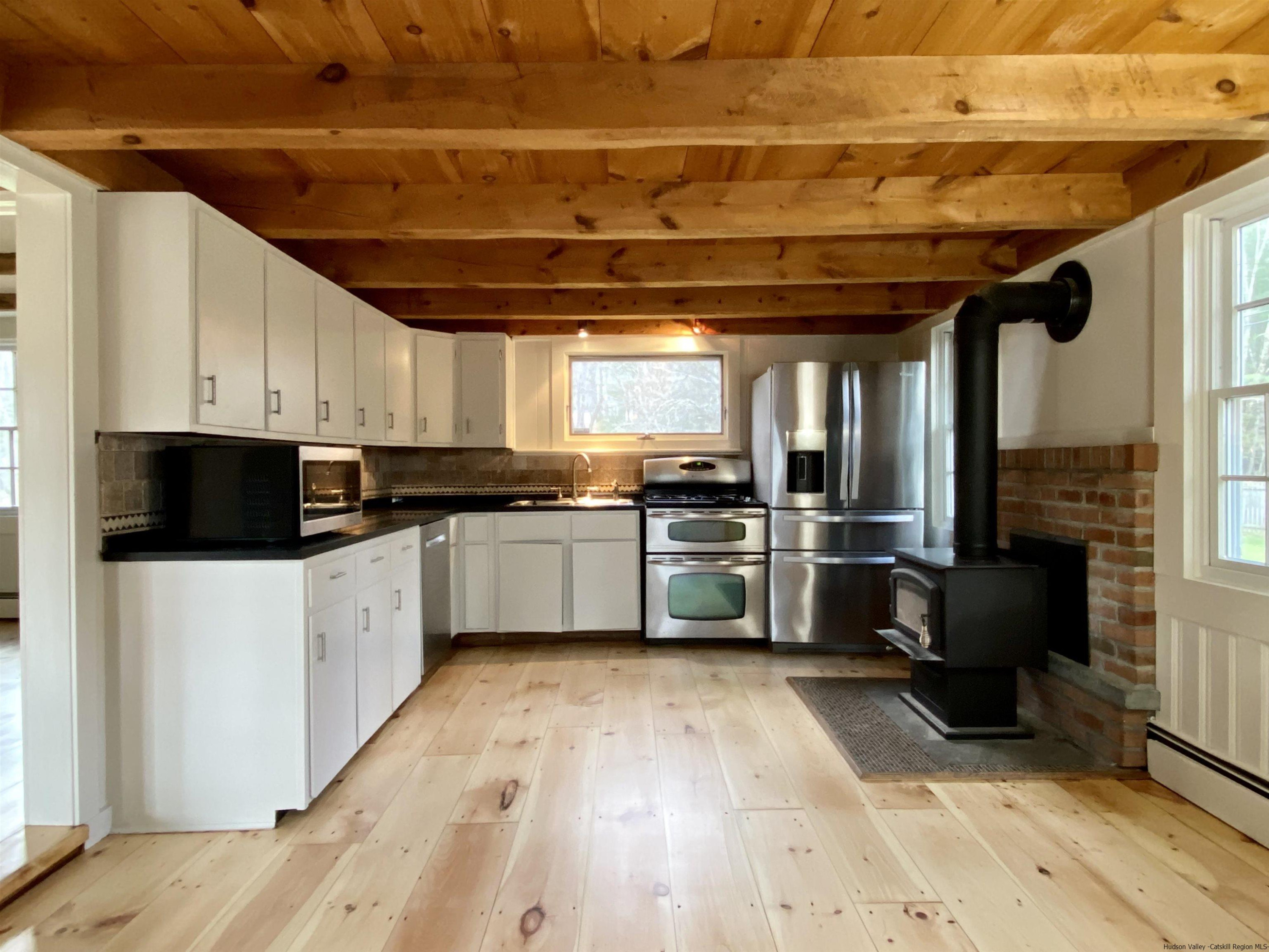83 Palentown Road Kerhonkson, NY 12446 - Photo 5 of 30 a kitchen with granite countertop a refrigerator oven a sink a window and white cabinets