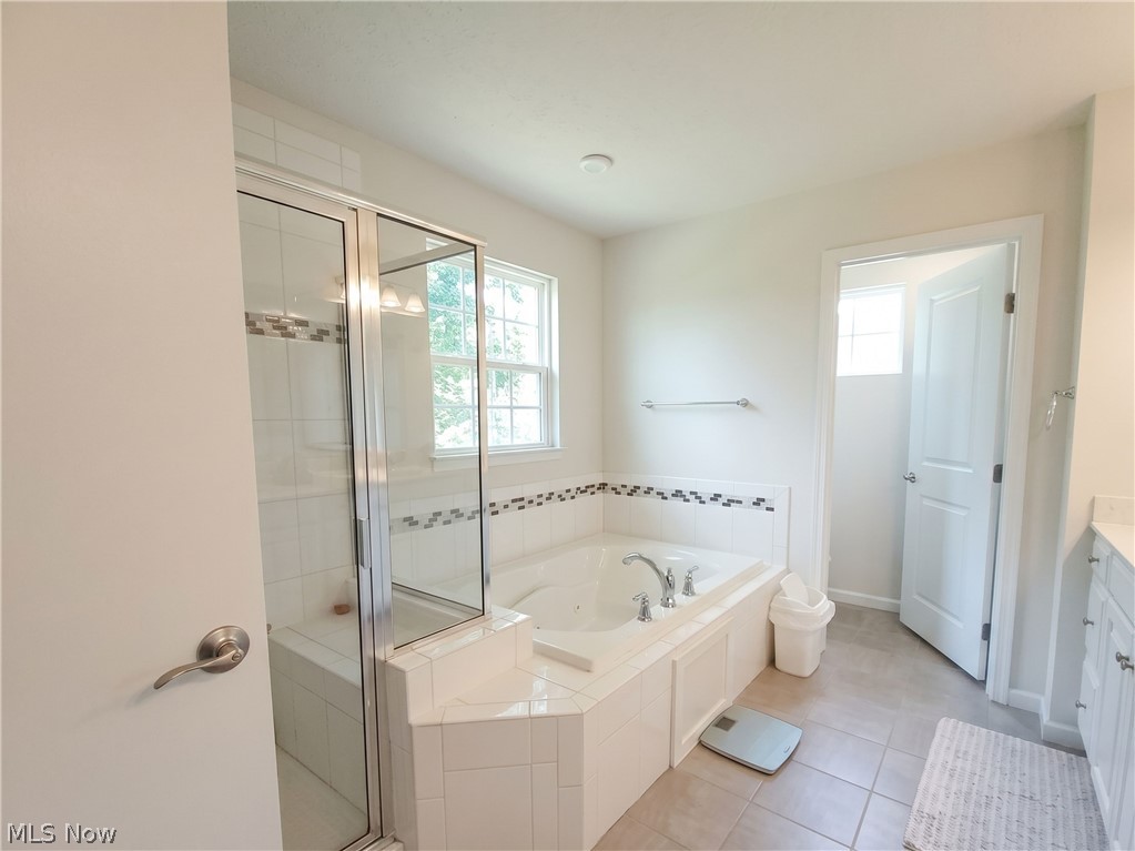 4509 Millbrook Way Akron, OH 44321 - Photo 21 of 27 Corner soaking tub with tiled surround featuring decorative border