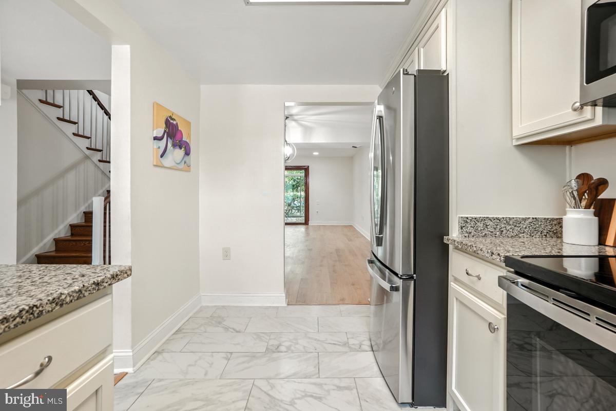3434 Gleneagles Drive, Unit 78B Silver Spring, MD 20906 - Photo 11 of 31 a kitchen with stainless steel appliances granite countertop a refrigerator and a stove top oven