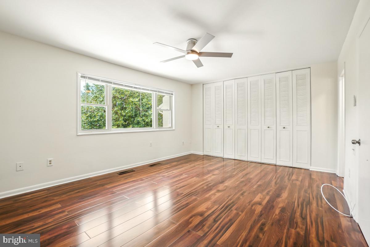 3434 Gleneagles Drive, Unit 78B Silver Spring, MD 20906 - Photo 22 of 31 a view of an empty room with wooden floor and a window