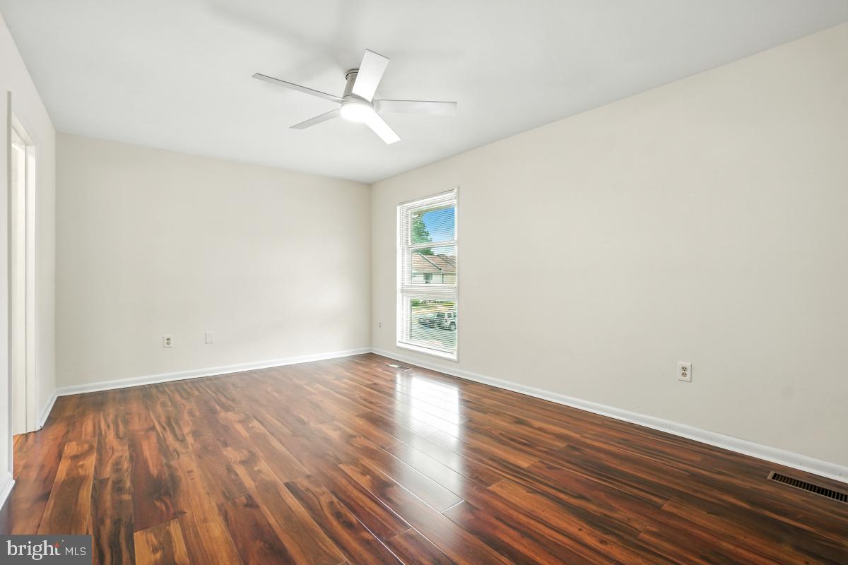 3434 Gleneagles Drive, Unit 78B Silver Spring, MD 20906 - Photo 29 of 31 a view of an empty room with wooden floor and a ceiling fan