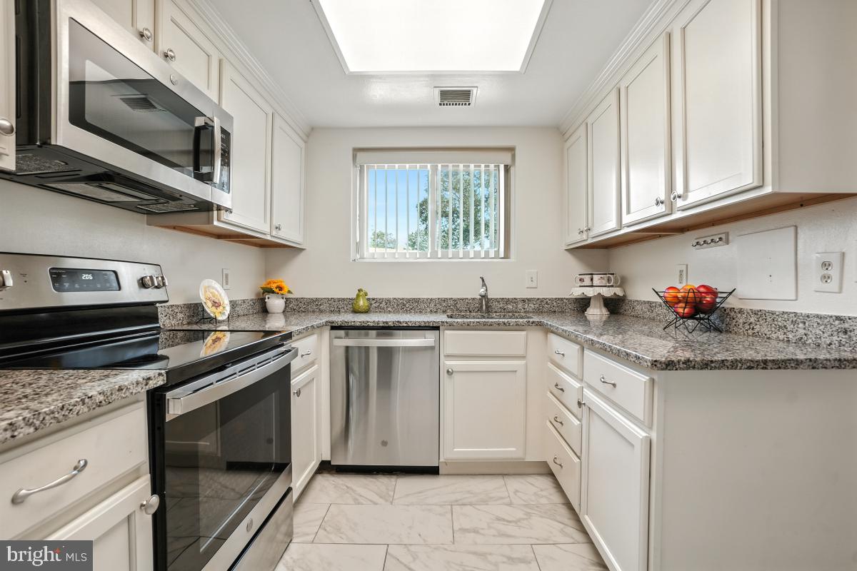 3434 Gleneagles Drive, Unit 78B Silver Spring, MD 20906 - Photo 8 of 31 a kitchen with stainless steel appliances granite countertop a sink stove and microwave