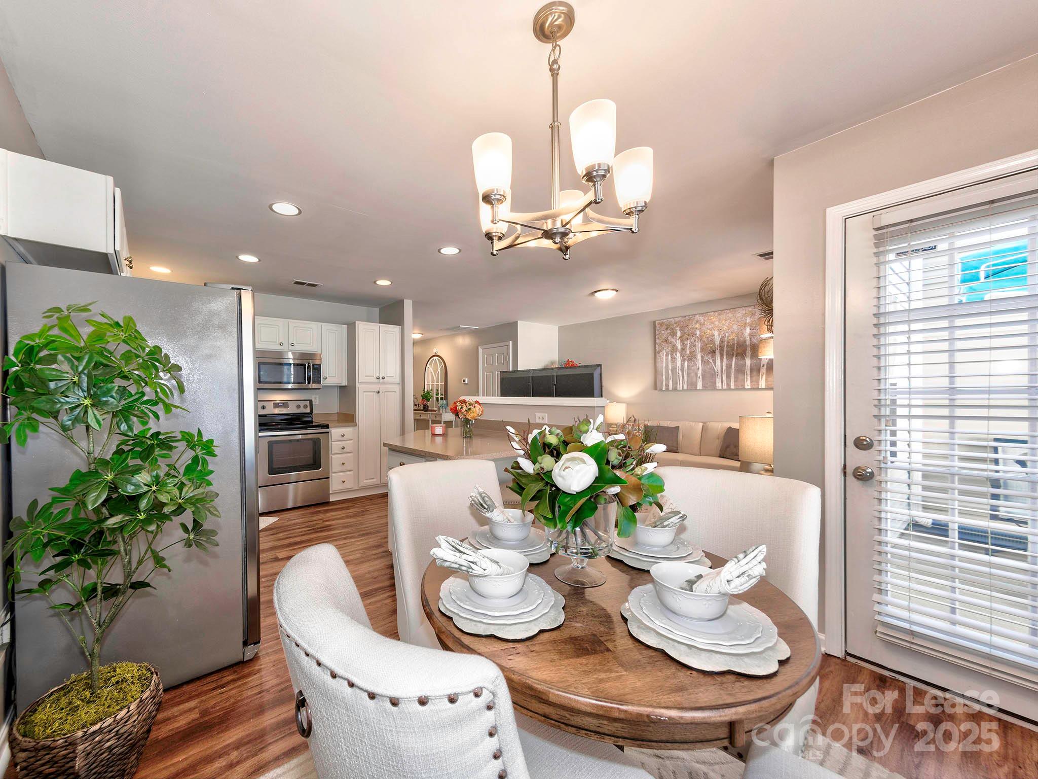 11316 Morgan Valley Lane Charlotte, NC 28270 - Photo 9 of 33 a view of a dining room with furniture a kitchen and chandelier