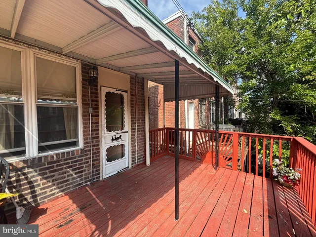 a balcony with wooden floor and outdoor seating