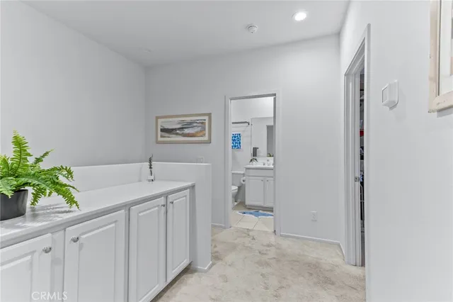 a spacious bathroom with a granite countertop sink and a mirror
