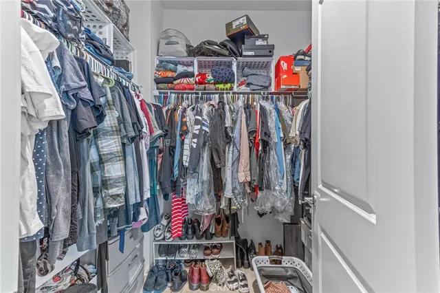 a view of walk in closet with clothes