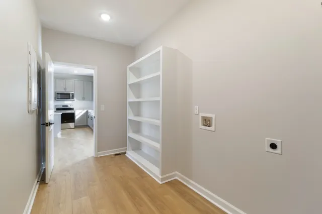 a view of a hallway with wooden floor and closet