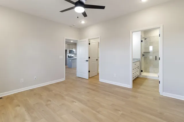 an empty room with closet and a chandelier fan