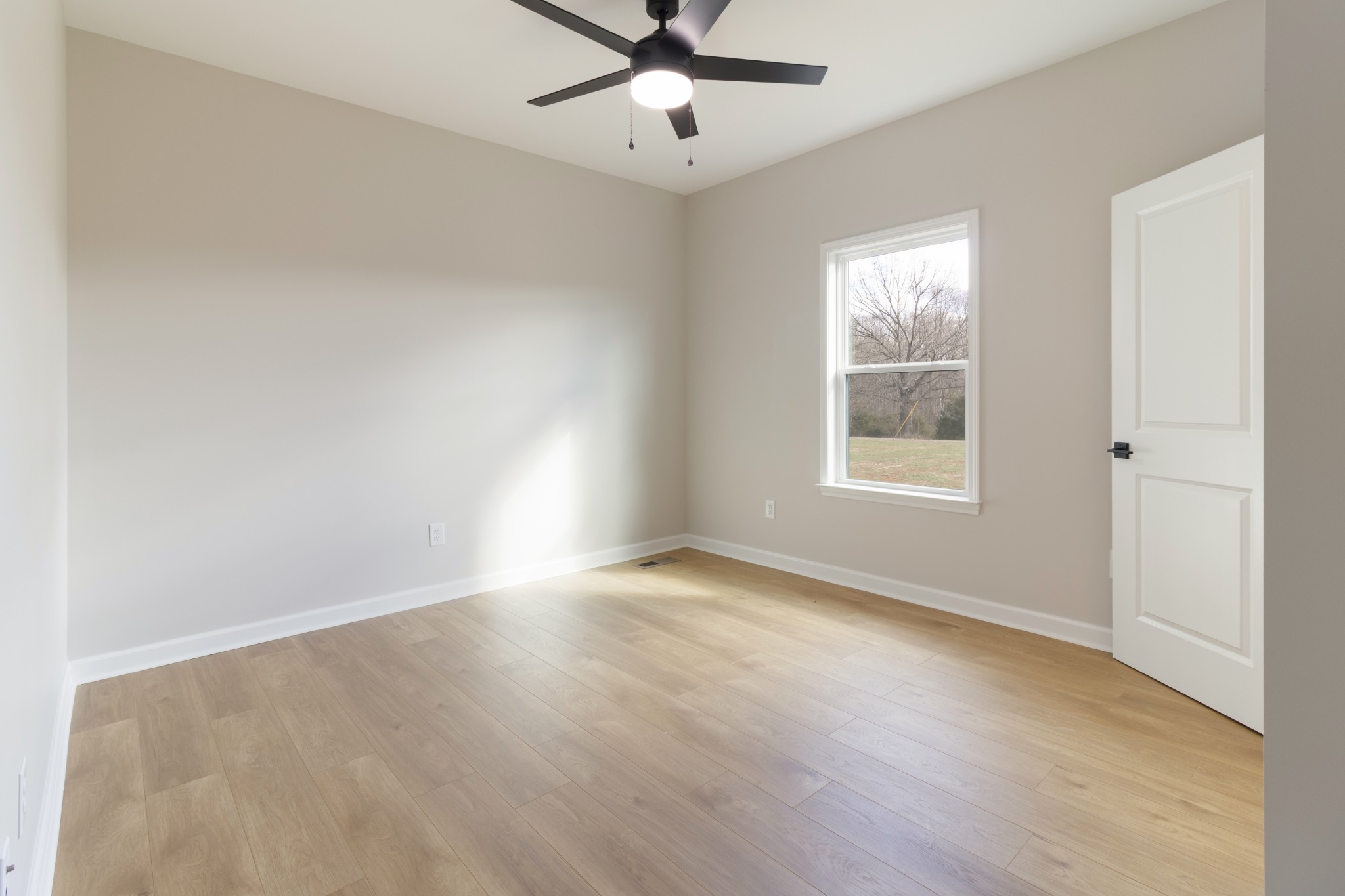 6170 Rocky Mound Road Westmoreland, TN 37186 - Photo 20 of 24 an empty room with wooden floor chandelier fan and windows