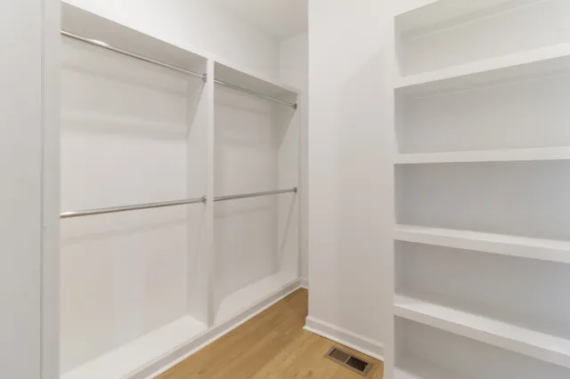 a view of walk in closet with empty racks