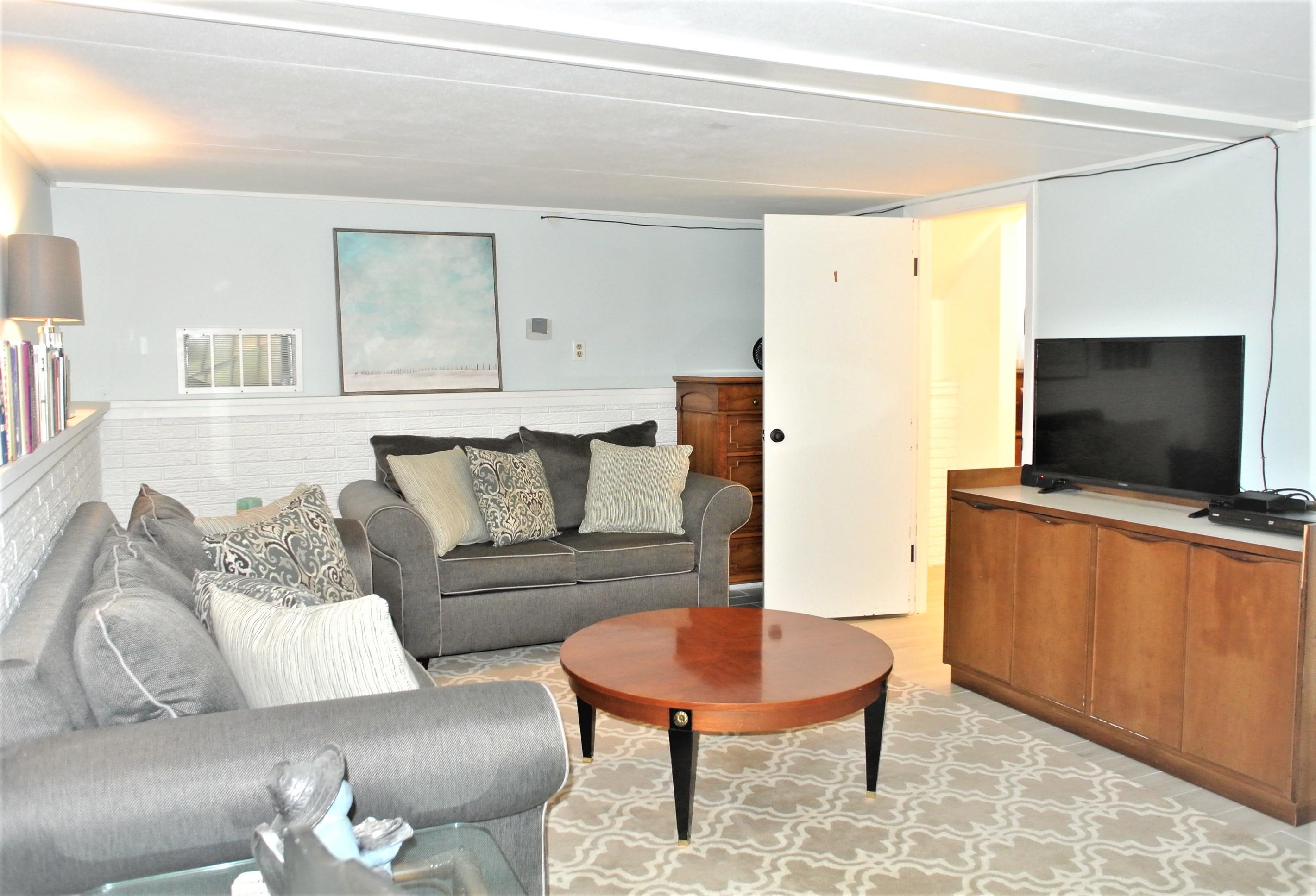 163 Greensward Road Mashpee, MA 02649 - Photo 20 of 37 a living room with furniture and a flat screen tv
