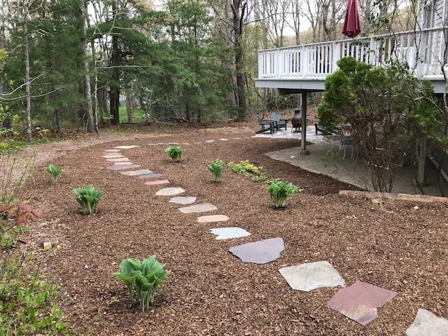 163 Greensward Road Mashpee, MA 02649 - Photo 32 of 37 a backyard of a house with lots of green space and glass windows