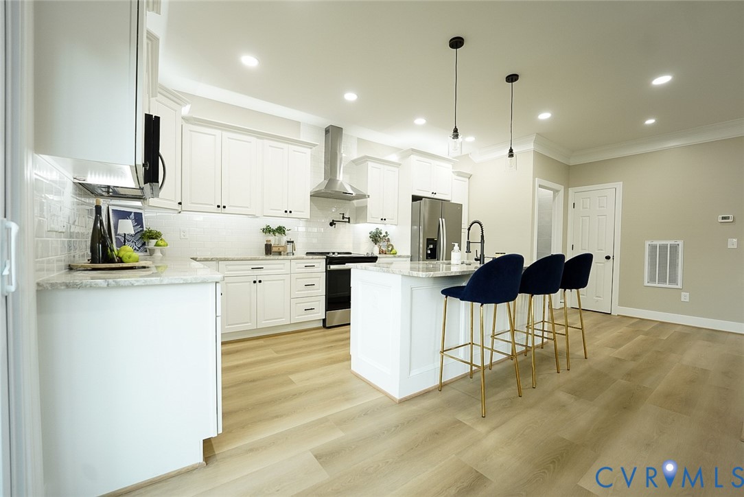 2328 Pocoshock Boulevard North Chesterfield, VA 23235 - Photo 8 of 29 a kitchen with kitchen island a stove a table and chairs in it