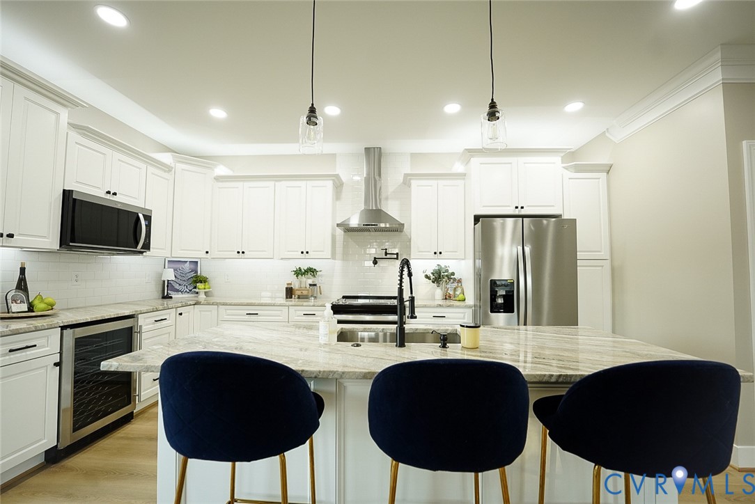 2328 Pocoshock Boulevard North Chesterfield, VA 23235 - Photo 9 of 29 a kitchen with stainless steel appliances kitchen island granite countertop a stove a refrigerator a sink dishwasher a dining table and chairs with wooden floor