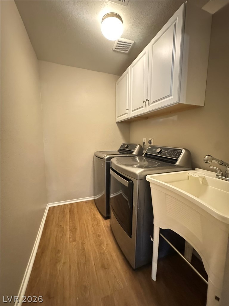 5141 South Lindell Road, Unit 102 Las Vegas, NV 89118 - Photo 11 of 17 Functional laundry room equipped with upper cabinetry and a utility sink.
