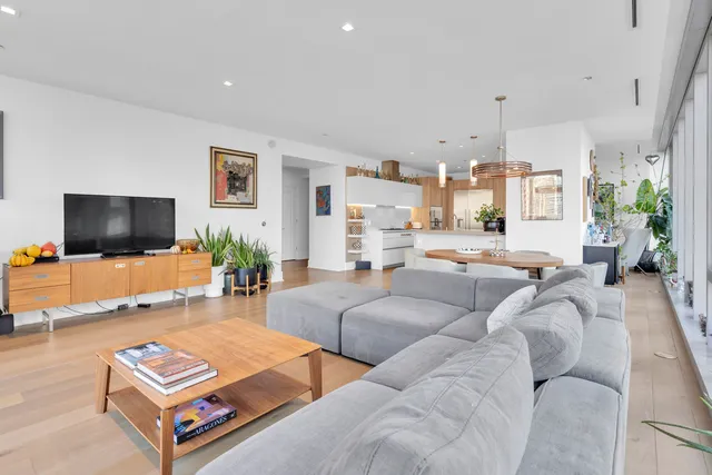 a kitchen with stainless steel appliances granite countertop a sink a counter top space and a view of living room