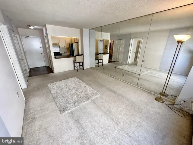 a view of a hallway with furniture and a living room