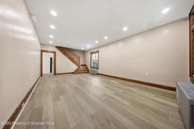 a view of an empty room with wooden floor