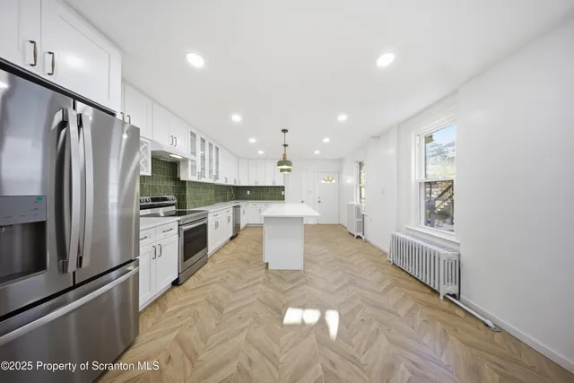 a kitchen with white cabinets and stainless steel appliances