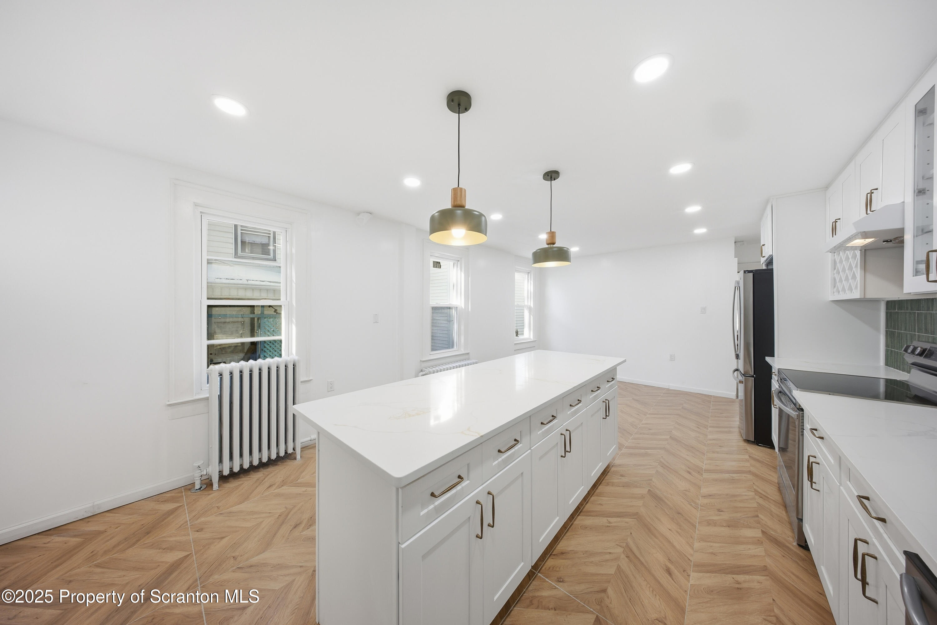 1312-14 North Washington Avenue Scranton, PA 18509 - Photo 10 of 22 a large kitchen with kitchen island a stove a sink a center island and couches