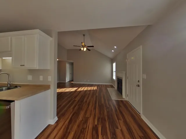 a view of a kitchen with a sink and wooden floor