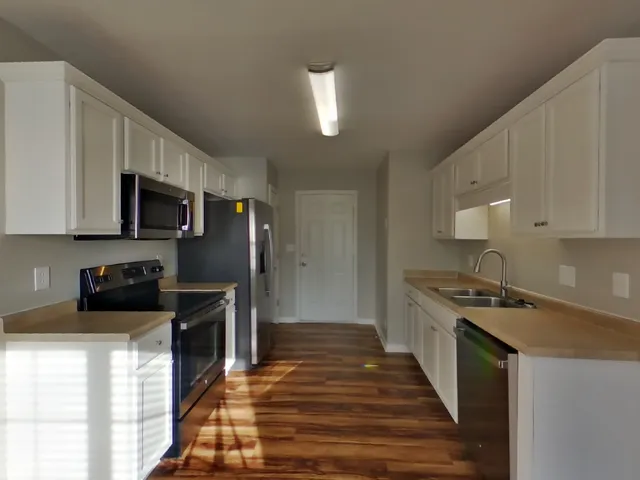 a kitchen with granite countertop a stove and a sink