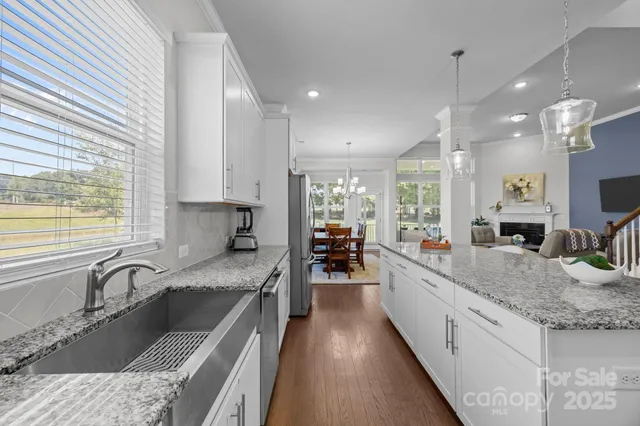 a large kitchen with granite countertop a large counter top a sink stainless steel appliances and cabinets
