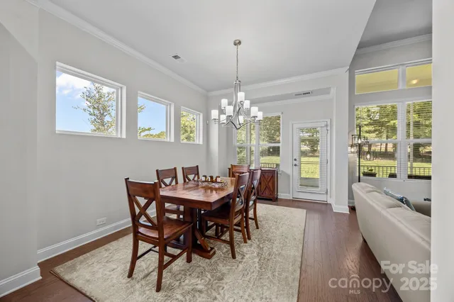 a view of a dining room with furniture a chandelier and wooden floor