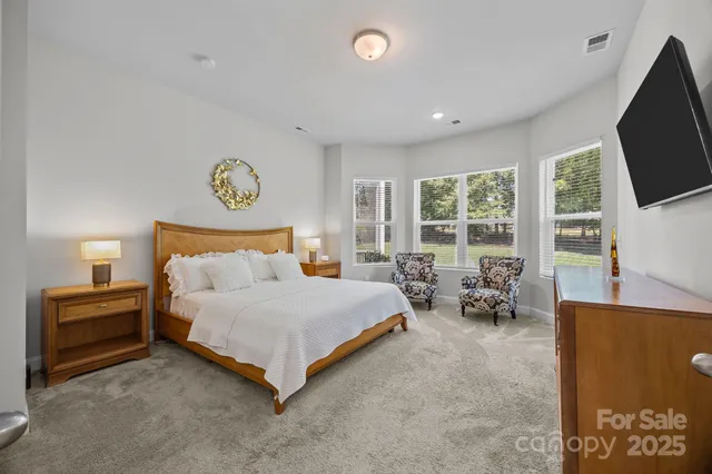 a spacious bedroom with a bed and a flat screen tv